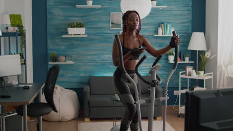 Cyclist-woman-with-black-skin-in-sportswear-training-body-muscle-using-elliptical