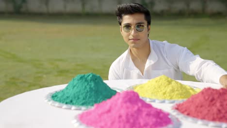 Cool-Indian-man-looking-at-colors-in-a-Holi-festival
