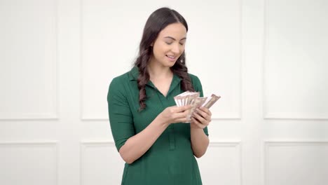 Indian-woman-counting-money-and-smiling
