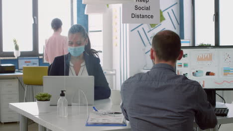 Business-team-with-face-masks-working-in-company-office-talking-precaution-to-mantain-safety-measures