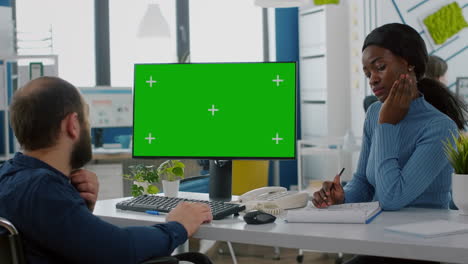 Diverse-businessteam-checking-with-financial-graphs-looking-at-green-screen