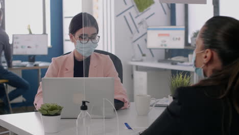 Business-team-with-face-masks-working-at-marketing-ideas