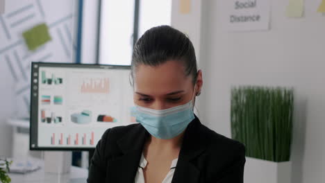 Portrait-of-business-woman-with-protective-face-mask-looking-into-camera