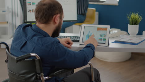 Paralyzed-manager-man-using-computer-and-tablet-in-same-time