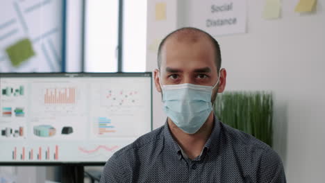 Closeup-of-employee-wearing-protection-medical-face-mask-looking-into-camera