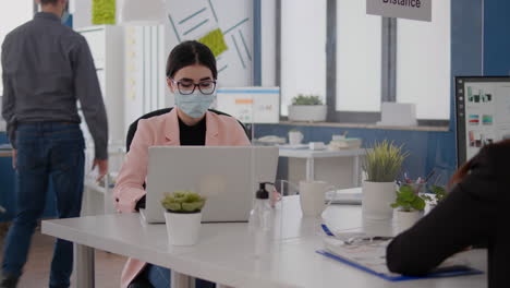 Business-people-with-medical-face-masks-working-together-in-new-normal-office