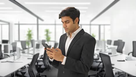 Indian-businessman-texting-on-phone