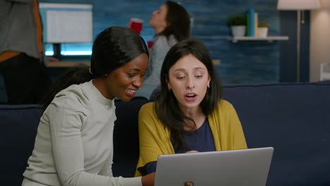 Multiracial-friends-laughing-while-watching-funny-video-on-laptop