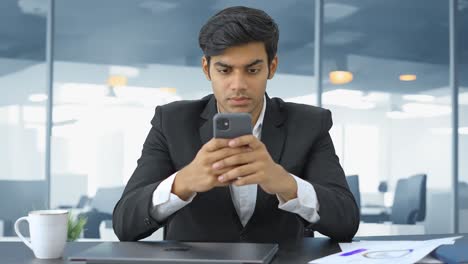 Angry-Indian-businessman-typing-on-mobile-phone