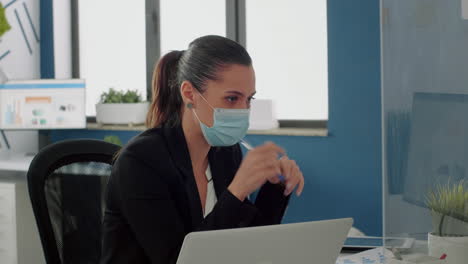 Businesswoman-with-medical-face-mask-talking-with-her-team-about-communication-strategy