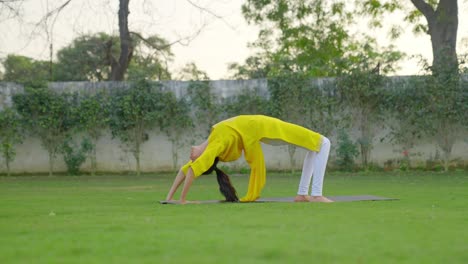 Niña-India-Haciendo-Pose-De-Yoga-Con-Rueda