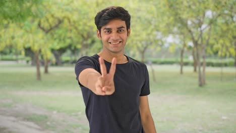 Indian-boy-showing-victory-sign-in-park