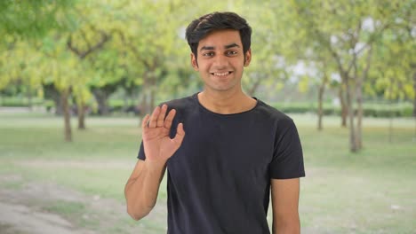 Happy-Indian-boy-saying-hi-and-waving-hand