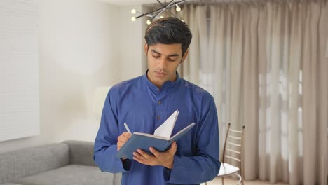 Young-Indian-man-thinking-and-writing-something