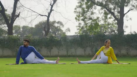 Eine-Halbe-Wirbelsäulendrehung-Yoga-Pose-Oder-Ardha-Matsyendrasana-Wird-Von-Einem-Indischen-Paar-Durchgeführt