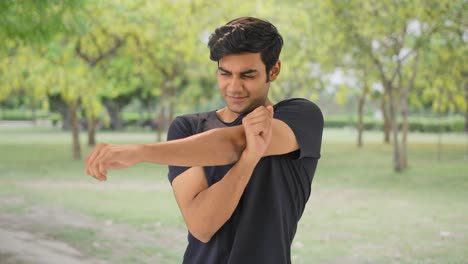 Happy-Indian-boy-doing-full-body-stretch-in-park