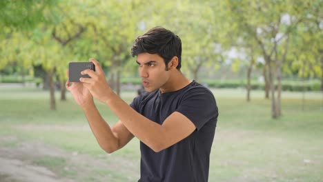 Curious-Indian-boy-clicking-pictures-in-a-park