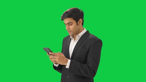 Wütender-Indischer-Geschäftsmann,-Der-Jemandem-Eine-SMS-Auf-Grünem-Bildschirm-Schreibt