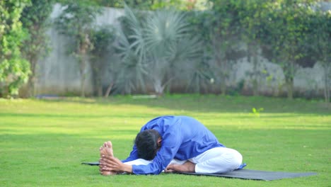 Indian-man-doing-knee-to-head-yoga-pose-in-side-angle
