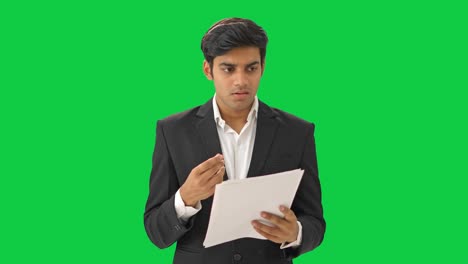 Gestresster-Und-Angespannter-Indischer-Manager-Liest-Verträge-Auf-Grünem-Bildschirm