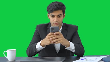 Angry-Indian-businessman-typing-on-mobile-phone-Green-screen