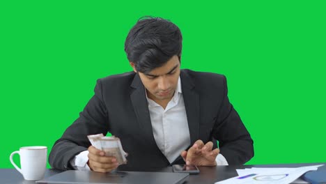 Sad-Indian-businessman-counting-the-money-Green-screen