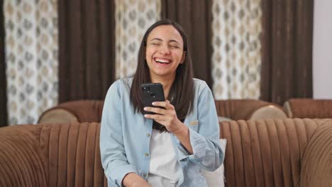 Happy-Indian-girl-laughing-while-using-phone
