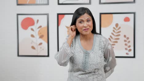 Middle-aged-Indian-woman-pointing-left-at-Copy-space