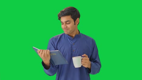 Glücklicher-Indischer-Mann,-Der-Tee-Trinkt-Und-Ein-Buch-Auf-Grünem-Bildschirm-Liest