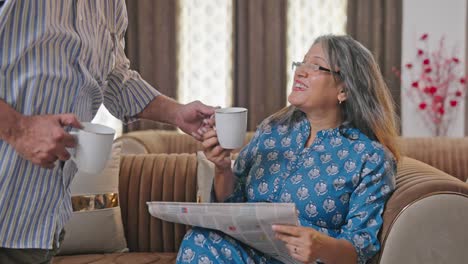 Indian-husband-brings-tea-for-his-wife-while-she-was-reading-newspaper