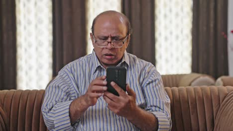 Old-Indian-man-trying-to-use-the-phone-for-the-first-time