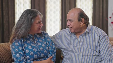 Happy-Indian-old-couple-talking-and-discussing