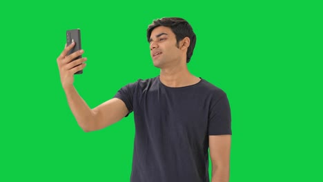 Indischer-Junge,-Der-Mit-Jemandem-über-Einen-Videoanruf-Auf-Grünem-Bildschirm-Spricht