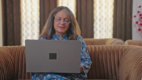 Glückliche-Indische-Mutter,-Die-An-Einem-Laptop-Arbeitet