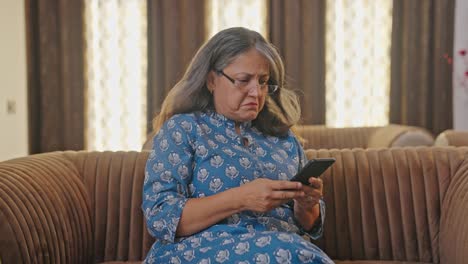 Ältere-Indische-Frau,-Die-Ihr-Mobiltelefon-Benutzt