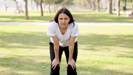 Woman-taking-long-breaths-after-a-workout-in-a-park-in-morning