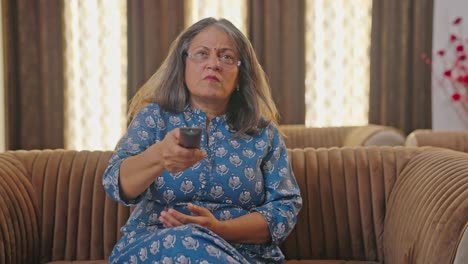 Ältere-Indische-Frau-Versucht,-Die-TV-Fernbedienung-Zu-Reparieren