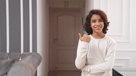 Happy-Indian-teenager-boy-pointing-left-for-copyspace