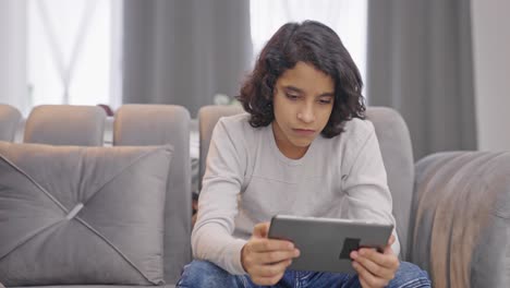 Serious-Indian-kid-boy-watching-informational-videos-on-social-media