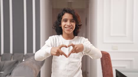 Happy-Indian-kid-boy-making-heart-gesture-with-hands