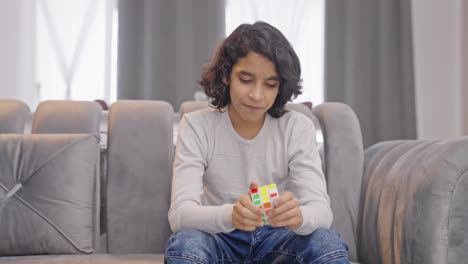 Glücklicher-Indischer-Teenager-Junge,-Der-Versucht,-Den-Zauberwürfel-Zu-Lösen