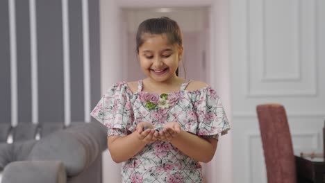 Glückliches-Indisches-Mädchen,-Das-Die-Münzen-Betrachtet-Und-Lächelt