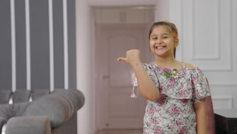 Cute-Indian-kid-girl-pointing-left-for-copyspace-for-product-placement