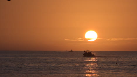 Ein-Motorboot-Fährt-Bei-Sonnenuntergang-über-Das-Meer