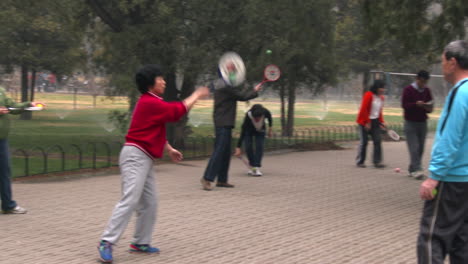 People-in-a-park-in-China-play-an-exercise-game-with-a-ball-and-paddle-
