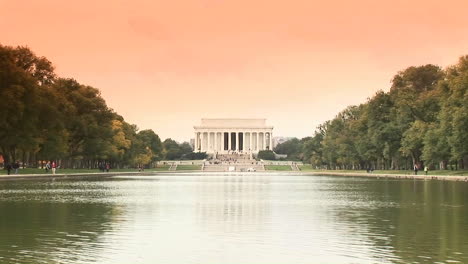 Eine-Lange-Aufnahme-Des-Lincoln-Denkmals-über-Dem-Reflektierenden-Pool-Mit-Enten,-Die-An-2-Vorbeischwimmen