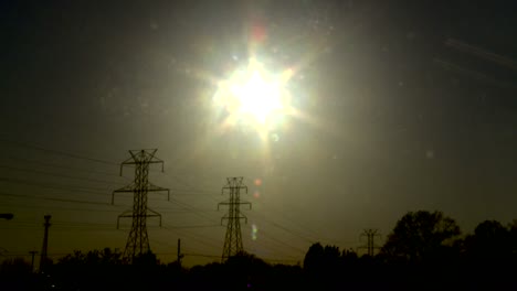 Time-lapse-of-the-sun-setting-behind-power-lines