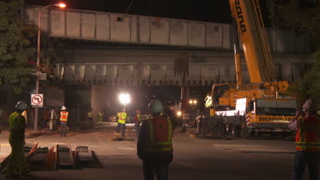 Construction-workers-work-on-a-freeway-overpass-at-night-in-Los-Angeles