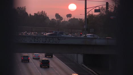Sonnenuntergang-über-Einer-Autobahn-An-Einem-Dunstigen,-Smogigen-Tag-In-Los-Angeles