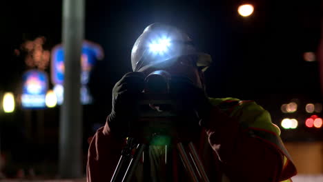 An-American-surveyor-works-at-night-on-a-road-construction-project